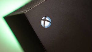 黑色遊戲主機上帶有綠色背光的發光Xbox標誌。
