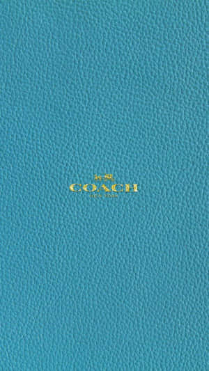 土耳其藍色皮革Coach錢包，帶金色標誌。
