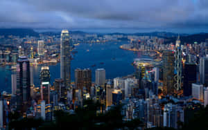 黃昏時分的香港城市景觀，燈火通明的摩天大樓和港口。