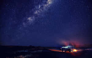 一輛汽車在夜晚停在沙漠公路上，星空下，附近有營火。