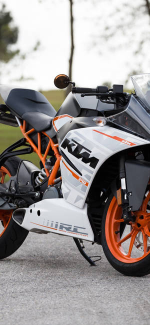 白色同橙色KTM RC運動電單車泊喺瀝青路上。