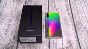 Samsung Note10+手機背面彩虹色，旁邊是黑色盒子，放在木頭上。