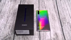 Samsung Note10+手機背面彩虹色,旁邊是黑色盒子,放在木頭上。