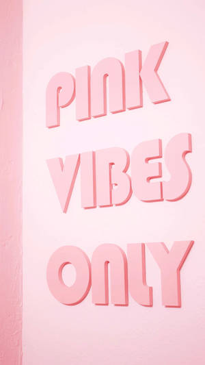 粉紅色 3D 字母在粉紅色牆上顯示 'PINK VIBES ONLY'。