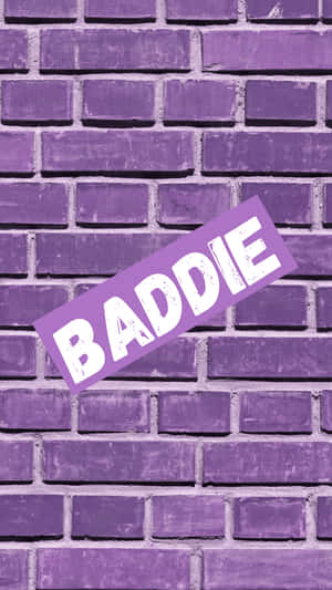 紫色磚牆上有一張傾斜的「BADDIE」貼紙。