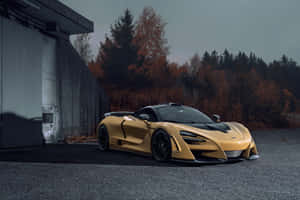 金色McLaren停泊在工業建築附近，有秋葉。