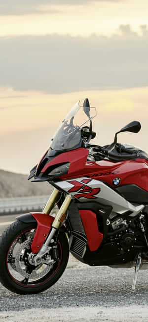 紅色BMW R 1200 GS電單車在日落時停泊在碎石上。 — Pixel 7a 壁紙