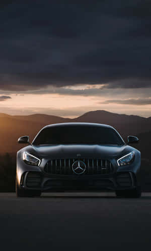 日落時分山路上的黑色梅賽德斯-AMG GT跑車