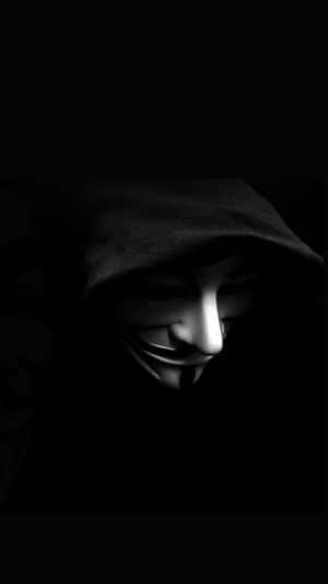 在黑暗環境中穿著連帽衫戴著蓋伊·福克斯面具的人
