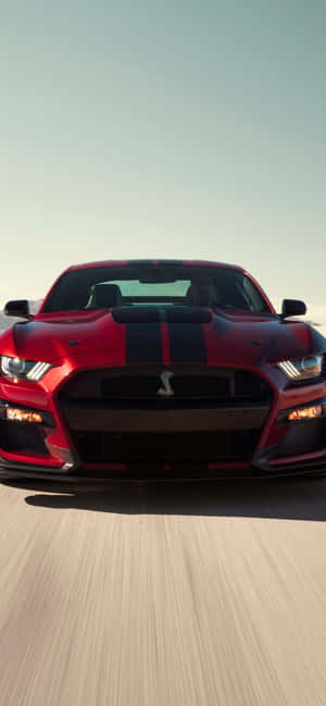 紅色Shelby Mustang在日落時分的道路上疾馳。