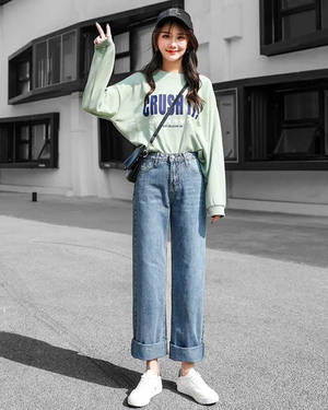 街頭風格的年輕女性在人行道上微笑並比出和平手勢。