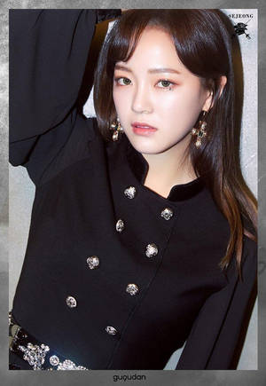 K-pop 藝人 Sejeong 身穿帶有銀色鈕扣的黑色大衣和搶眼的耳環。