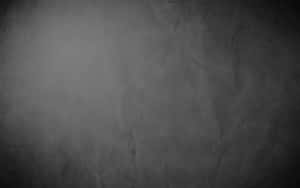深灰色紋理紙張，帶有柔和暈影漸變和細微皺褶。 — 黑色美學 壁紙