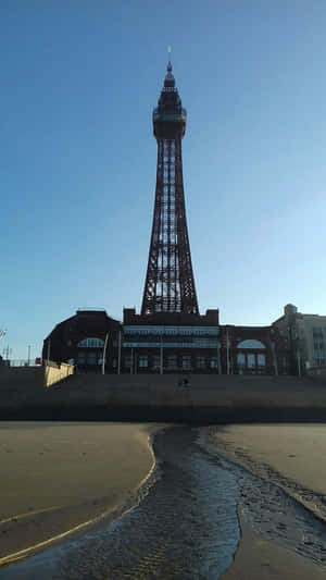 日落時分的 Blackpool Tower 與海灘上的海浪
