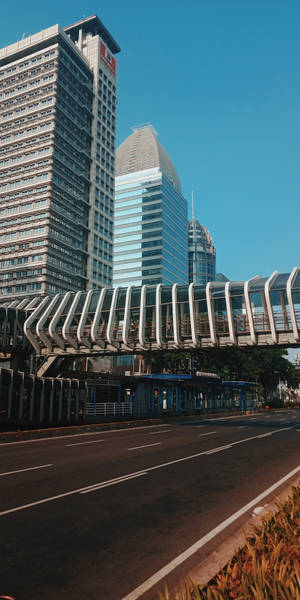 城市街道，高樓大廈和人行天橋在晴朗的藍天下。