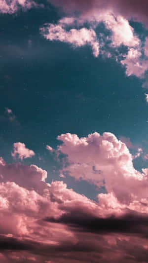 粉紅色的雲朵漂浮在藍綠色的星空上。