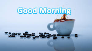 咖啡杯在藍色反光表面上散落咖啡豆，帶有「Good Morning」文字。 — 早晨咖啡 壁紙