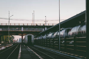 黃昏時分的火車站，油罐車廂及天橋上的人們。