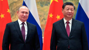 外交會議期間，兩名身穿西裝的男子站在俄羅斯和中國國旗前。 — 政治 壁紙