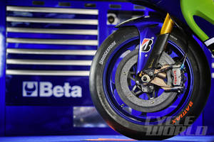 藍色和綠色電單車輪，配備Brembo制動器和Bridgestone輪胎，靠近Beta工具箱。