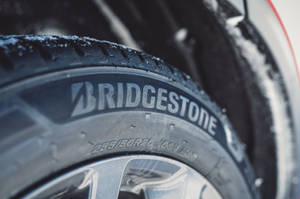 帶有 Bridgestone 品牌標誌的積雪汽車輪胎特寫。