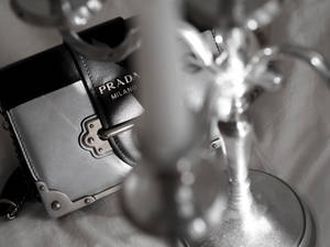一個 Prada 手袋和華麗燭台的單色特寫。