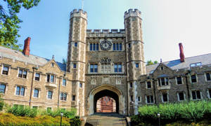 石造大學門房，擁有雙塔和拱形入口。 — 花園牆外 壁紙