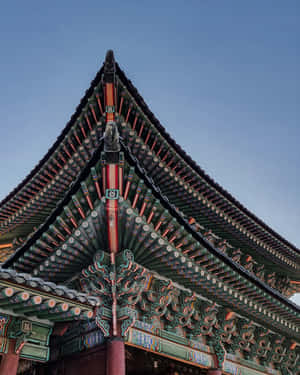 在清澈的藍天下，傳統韓國寺廟屋頂的特寫，帶有色彩繽紛的裝飾元素。