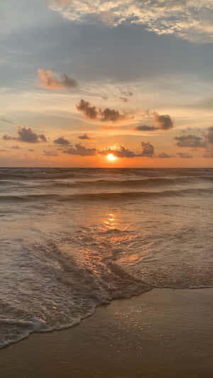 夕陽映照海洋，海浪沖刷沙灘。 — 海灘日落 壁紙