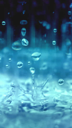 水滴在冷藍色調中落下並飛濺的特寫。 — 湖景 壁紙