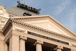 Academia de Bellas Artes 的外牆，帶有古典柱子和裝飾性雕刻。 — 設計 壁紙