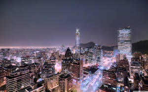 夜晚的城市景觀，建築物閃爍光芒，街道繁忙。 — 極光 壁紙