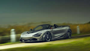 銀色McLaren 720S Spider在鄉村道路上疾馳，背景模糊。
