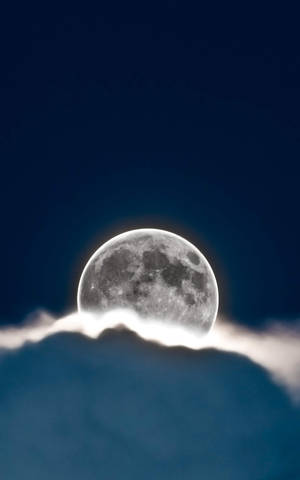 滿月在黑暗夜空的雲層上發光。