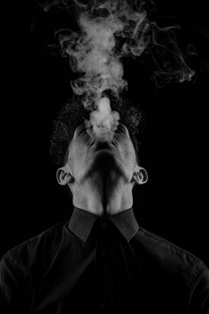 男人在黑白工作室肖像中向上呼出煙霧。 — 暗色 壁紙