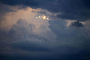 暴風天空下，金色陽光穿透的戲劇性雲層。