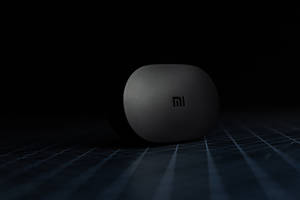 時尚黑色Xiaomi耳機盒在深色網格上，帶聚光燈效果。 — Xiaomi 壁紙