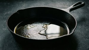 深色枱面上的鑄鐵鍋與油
