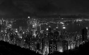 黑白夜景城市景觀，燈火通明的摩天大樓和港灣。