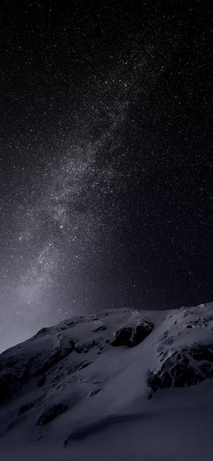 白雪覆蓋的山峰，在星空下，銀河清晰可見。