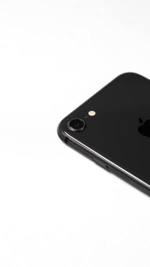 黑色iPhone一角，帶有相機和標誌，置於白色背景上 — 深色iPhone壁紙
