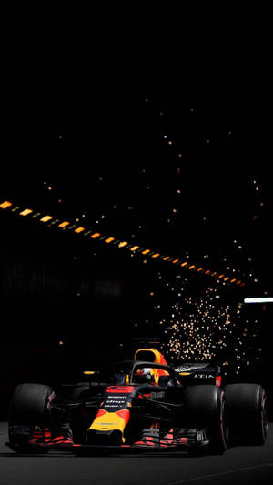 紅牛F1賽車在夜間疾馳，車後火花飛濺。