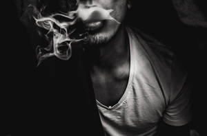 男人在黑暗的黑白肖像中呼出煙霧。