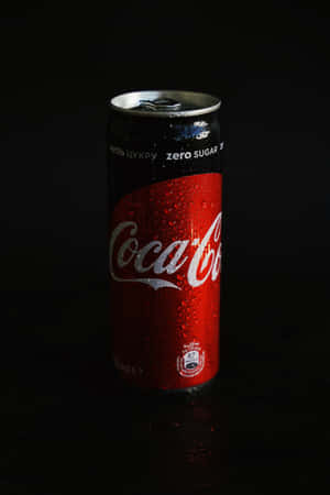 冰凍的Coca-Cola Zero Sugar罐在深色表面上帶有冷凝水珠