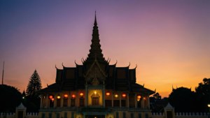 日落時分，燈籠照亮的高棉寺廟，天空呈現紫色和橙色。