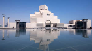 白色現代博物館倒映在平靜水面上，藍天之下 — 建築 壁紙
