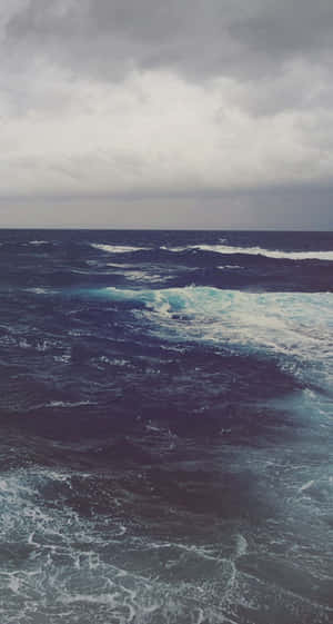 在暴風雨的灰色天空下，黑暗的海浪翻騰。 — 水下 壁紙