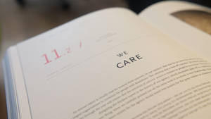 書本頁面特寫，顯示 '11.2' 和 'WE CARE' 文字。