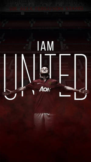 身穿紅色球衣的足球運動員在奧脫福球場內，雙臂張開，站在 'I AM UNITED' 文字下方。
