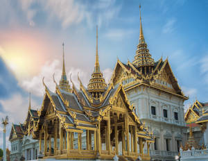金色泰國寺廟，在藍天下夕陽時分帶有精緻尖頂。